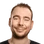 Porträt eines Mannes mit kurzem Bart, dunklem Haar, leichtem Lächeln und schwarzem T-Shirt.