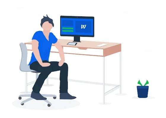 Person sitzt am Schreibtisch vor Monitor; auf dem Tisch liegen Papiere; rechts steht ein kleiner Pflanztopf.