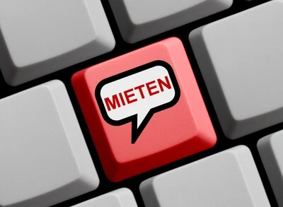 Rote Tastenkappe mit Sprechblasen-Symbol und dem Text MIETEN, umgeben von grauen Tasten.