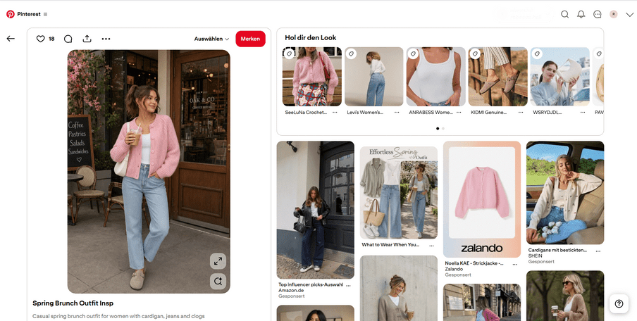 Frau in pinkem Cardigan und Jeans steht vor einer Holztür und hält ein Getränk.
