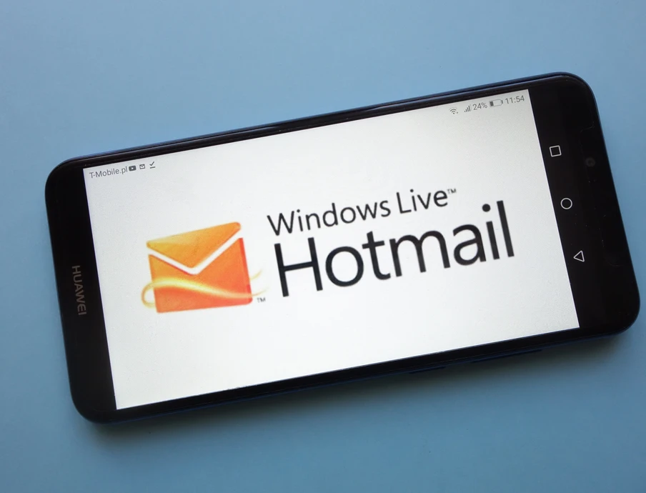 Schräg liegendes Smartphone auf blauem Hintergrund; Display zeigt Windows Live Hotmail-Logo.