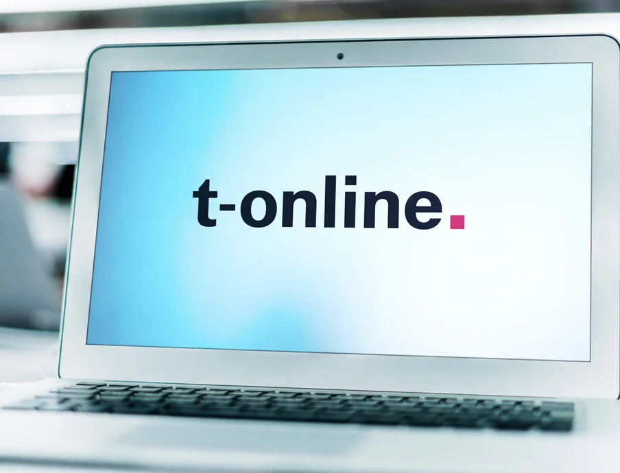 Laptop auf einem Tisch, Bildschirm zeigt t-online.