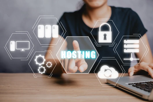 Person tippt auf Laptop; umgeben von hexagonalen Symbolen mit Servern, Monitor, Cloud, Schloss und HOSTING.