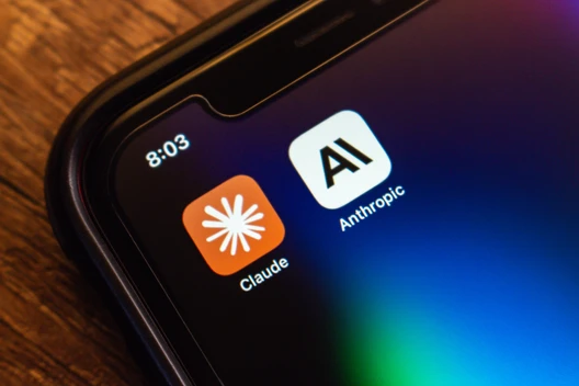 Nahaufnahme eines Smartphone-Bildschirms mit zwei App-Symbolen: Claude (orange, Sternblitz) und Anthropic (weiß, AI). Uhr 8:03