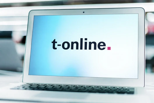 Laptop auf einem Tisch, Bildschirm zeigt t-online.