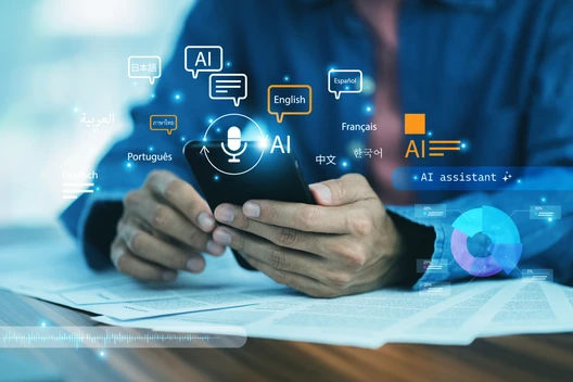 Hände halten Smartphone, umgeben von AI-Symbolen und Sprachen-Icons vor blauem Hintergrund.